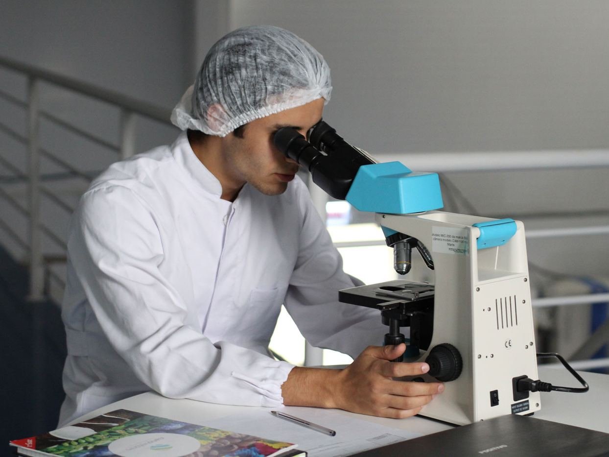 Profissional analisando amostra ao microscópio